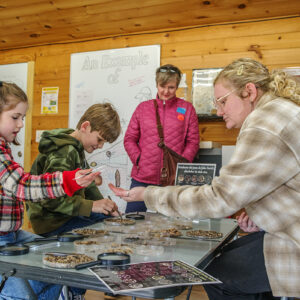 Assistant Curator Magen Hodapp helps visitors to the Ed Shed find tiny artifacts from objects excavated from John Smith's Well.