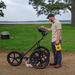 Director of Archaeology Sean Romo uses ground-penetrating radar (GPR) to check for any underground features prior to testing of the depth of the gravel pathway.